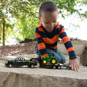 Boy playing with truck and tractor